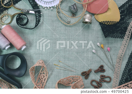 Sewing scene table flat lay composition. Threads, lace, pins, scissors, tape, reel, cloth. Pastel Sewing scene table flat lay composition. Threads, lace, pins, scissors, tape, reel, cloth. Pastel 49700425