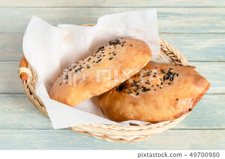 Basket with fresh bread on wooden table Basket with fresh bread on wooden table 49700980