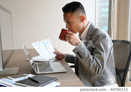 Businessman drinking coffee with hand documents Businessman drinking coffee with hand documents 49706315