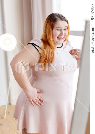 Joyful happy woman looking at her reflection Joyful happy woman looking at her reflection 49707490