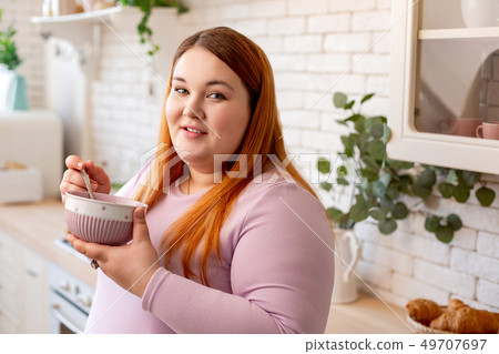 Pleasant good looking woman eating her food 49707697