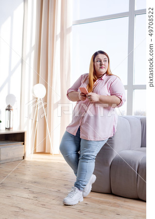 Good looking plump woman standing in the living room 49708522