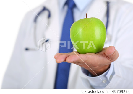 Male medicine therapeutist doctor hands holding green fresh ripe apple 49709234