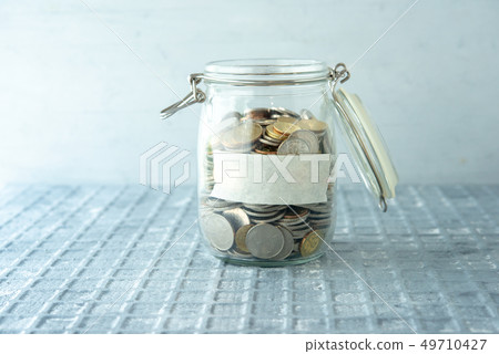 Saving jar with coins 49710427