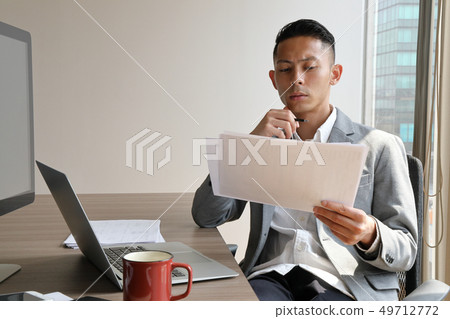 Businessman thinking with his hand on chin Businessman thinking with his hand on chin 49712772