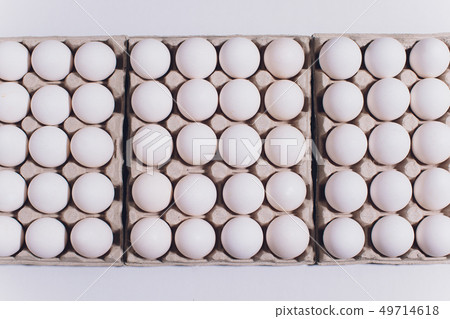 White eggs of a hen in harmless, cardboard packing on a white background. White eggs of a hen in harmless, cardboard packing on a white background. 49714618