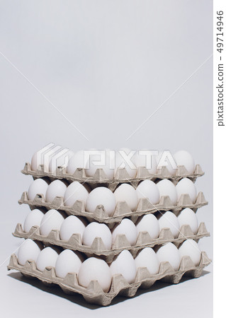 White eggs of a hen in harmless, cardboard packing on a white background. 5 packs. 49714946