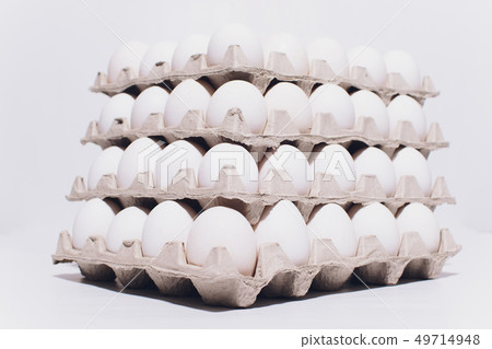 White eggs of a hen in harmless, cardboard packing on a white background. 5 packs. 49714948