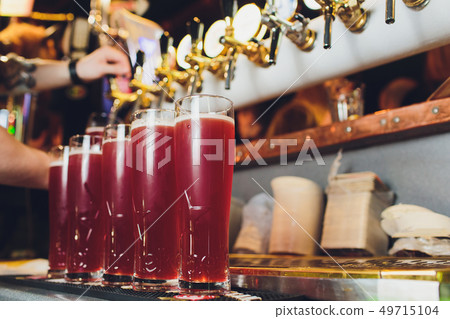 Hand of bartender pouring a red ale from tap. Bar life. Hand of bartender pouring a red ale from tap. Bar life. 49715104