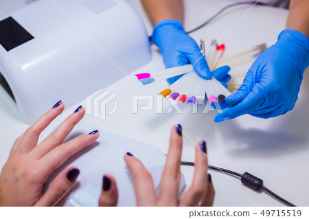 Nail technician shows the color palette of nail services in beau 49715519