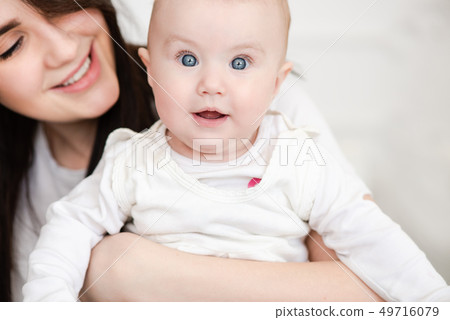 Baby girl blue eyes in mama hugs Baby girl blue eyes in mama hugs 49716079