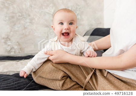 Portrait of smiling cute baby girl indoors 49716128