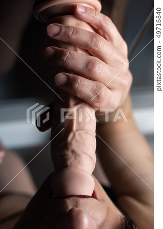 Close-up of female mouth with rubber dildo 49716840
