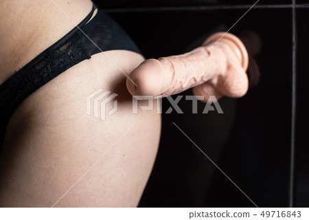Rubber dildo in touch to woman butt close up 49716843