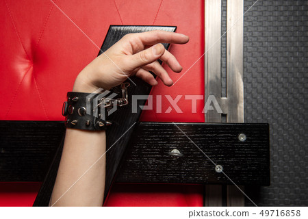 Close-up of female hand chained with handcuff. Close-up of female hand chained with handcuff. 49716858