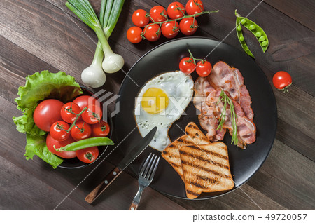 Egg and bacon on plate 49720057