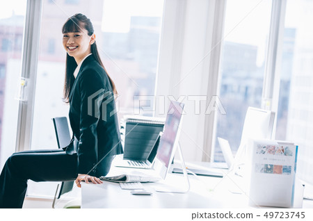 坐在書桌的新的新兵婦女在辦公室 坐在書桌的新的新兵婦女在辦公室 49723745