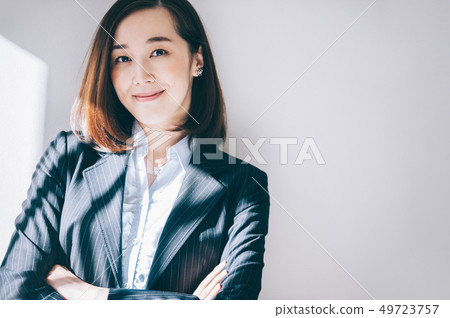Smiling woman leaning on pillar at office Smiling woman leaning on pillar at office 49723757