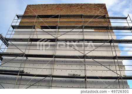 Insulating old flat house brick wall with white polystyrene 49726301