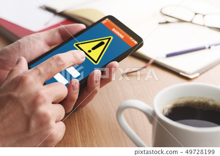Up of a male hand tapping on the smartphone screen where a security alert is displayed. 49728199