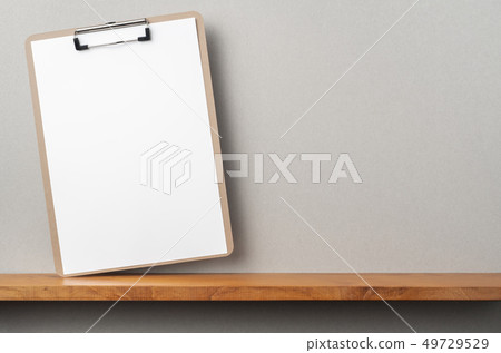front view of A4 paper with clipboard on bookshelf 49729529