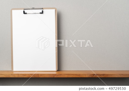 front view of A4 paper with clipboard on bookshelf front view of A4 paper with clipboard on bookshelf 49729530