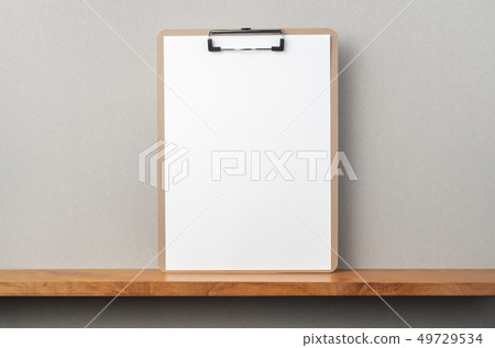 front view of A4 paper with clipboard on bookshelf front view of A4 paper with clipboard on bookshelf 49729534