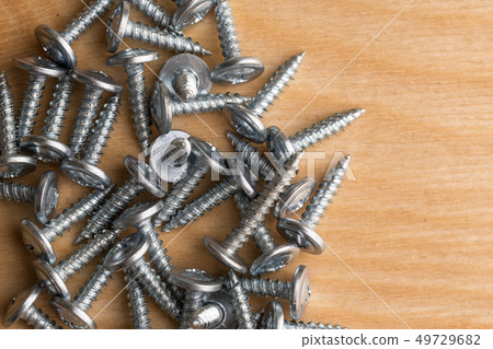 Screws, lying on a wooden table. Carpenter Screws, lying on a wooden table. Carpenter 49729682