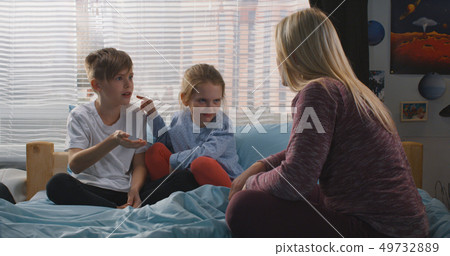 Mother talking with bickering siblings Mother talking with bickering siblings 49732889