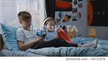 Boy and girl relaxing together on bed Boy and girl relaxing together on bed 49732970