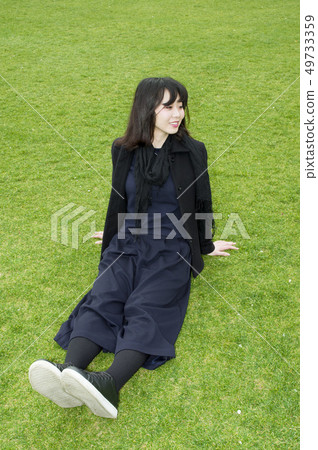 A woman relaxing on the lawn A woman relaxing on the lawn 49733359