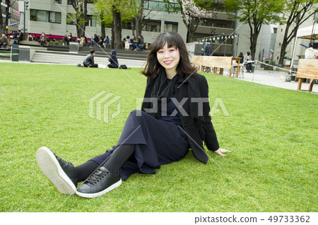 A woman relaxing on the lawn A woman relaxing on the lawn 49733362