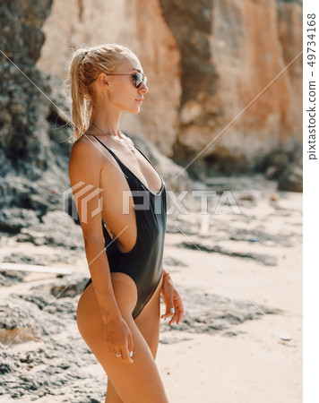 Attractive young woman in swimwear at ocean beach Attractive young woman in swimwear at ocean beach 49734168