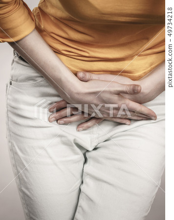 Woman with hands holding her crotch 49734218