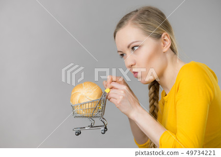 Woman holding shopping cart with bread 49734221