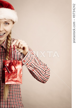 Happy shopping woman wearing Santa hat Happy shopping woman wearing Santa hat 49734242