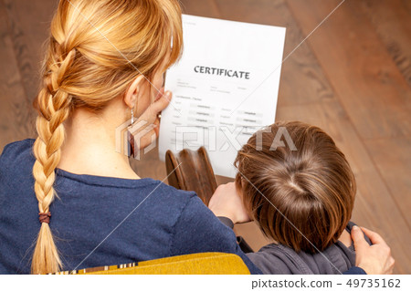 Mother comforting son despite the bad school certificate 49735162