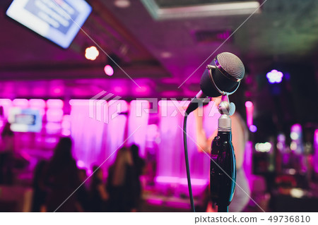 Retro microphone against blur colorful light in pub and restaurant background. Retro microphone against blur colorful light in pub and restaurant background. 49736810