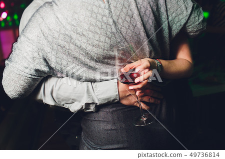 Glass of wine in beautiful female hands. Large glass filled with red wine in woman manicured hands Glass of wine in beautiful female hands. Large glass filled with red wine in woman manicured hands 49736814