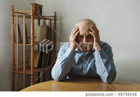 Worried elderly man with his head in his hands Worried elderly man with his head in his hands 49738438