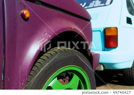 Burgundy car with green wheels on the road Burgundy car with green wheels on the road 49740427