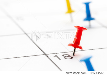 Colored push pin on white calendar background. Copy space for text. 49743565