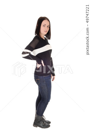 Pretty young woman standing in jeans in profile Pretty young woman standing in jeans in profile 49747221