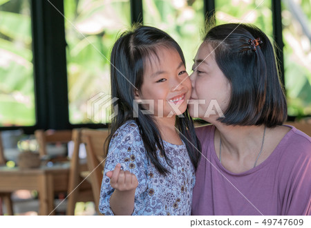 Mother is kissing daughter 49747609