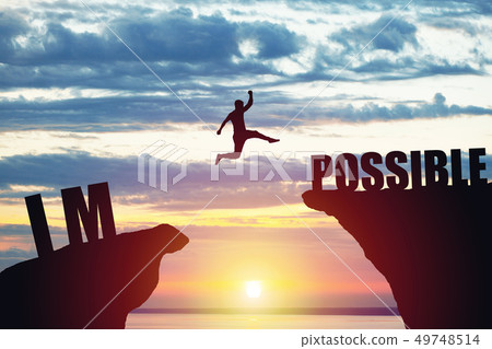 Man jumping over impossible or possible over cliff on sunset background Man jumping over impossible or possible over cliff on sunset background 49748514