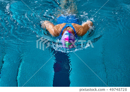 Female athlete swims with a butterfly style. 49748728