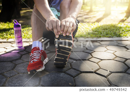 Asian athletes are stretching his legs Asian athletes are stretching his legs 49749342