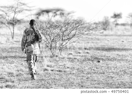 a black soldier and his gun looking the boarder a black soldier and his gun looking the boarder 49750401