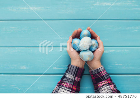 Female hand holding Easter eggs in hands Female hand holding Easter eggs in hands 49751776