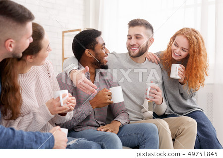 Cheerful friends drinking coffee and enjoying their company Cheerful friends drinking coffee and enjoying their company 49751845
